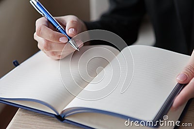 The girl makes entry in a notebook. close up Stock Photo