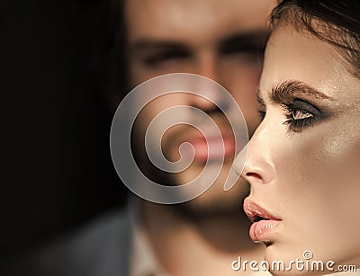 Girl with makeup, eyeshadows, blush, foundation. Woman face profile with blurred man on background. Couple of fashion Stock Photo