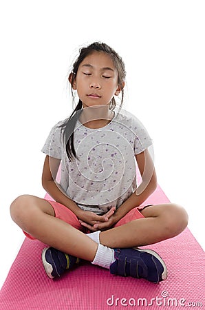 Girl making meditaion on pink yoga mat with white background.. Stock Photo
