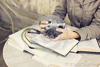 Girl with many open books and old style camera Stock Photo