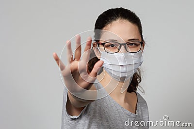 A girl in a mask shows a stop gesture fearing for the health of people Stock Photo