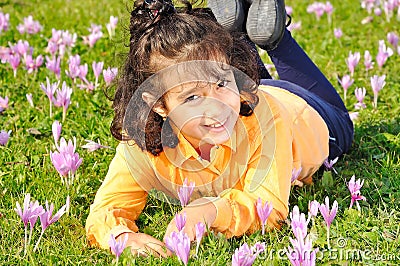 Girl on meadow with pink flowers arond Stock Photo