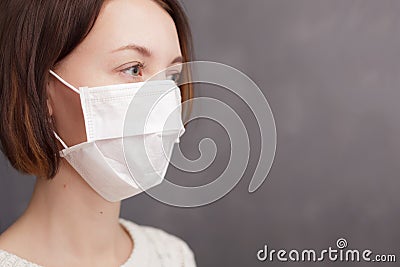 Girl in medical disposable mask looking at the camera. Stock Photo