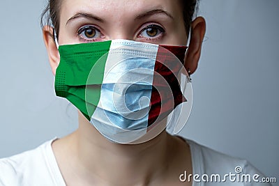 Girl in a medical protective mask. Abstract Italy flag on fabric. Coronovirus Pandemic Concept COVID-19 Stock Photo