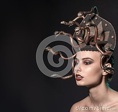 Girl Medusa headdress of gold color on a black background Stock Photo