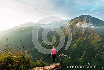 Girl meets sunrise in the mountains. Girl traveling to Sri Lanka. Mountain sports. Athlete happy finish. Mountain tourism Editorial Stock Photo