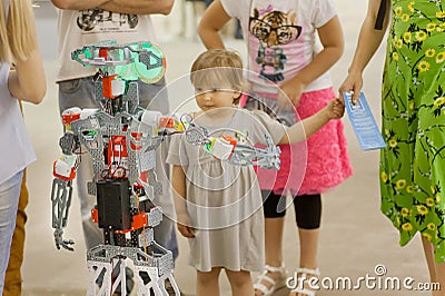 Girl met with a mechanical robot at the exhibition of young technician designers Editorial Stock Photo