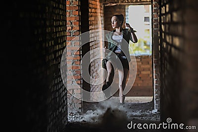 Girl near the brick wall in military style. Stock Photo