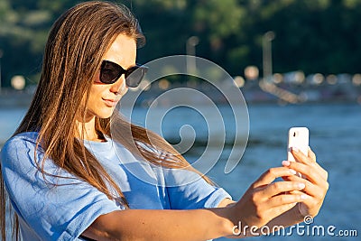 Girl near the river against the sky having fun. selfie. Summer vibes Stock Photo