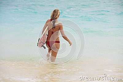 Girl in the ocean with her surfboard Stock Photo