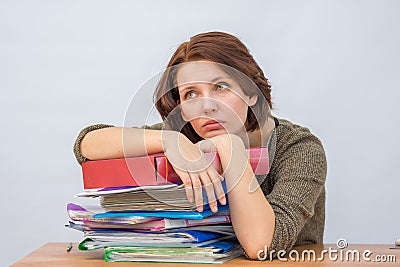 Girl office staff thoughtfully leaning on a stack of folders Stock Photo