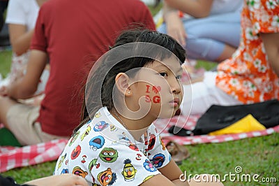 A girl with one side of her face painted during a gathering at the Marina Barrage Roof Garden Editorial Stock Photo