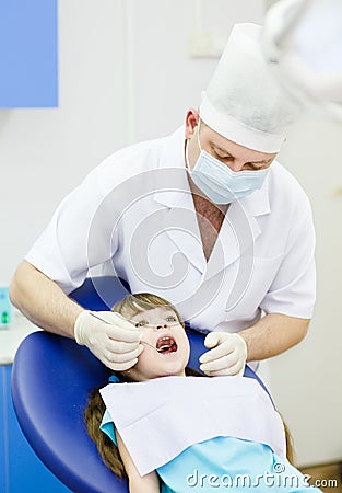 Girl with open mouth while it being examined by de Stock Photo