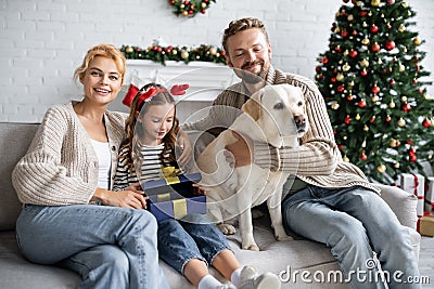 Girl opening christmas present near parents Stock Photo