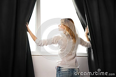 Girl opens the curtains and relaxing in morning Stock Photo