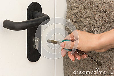 The girl opens the front door with a key, close-up Stock Photo