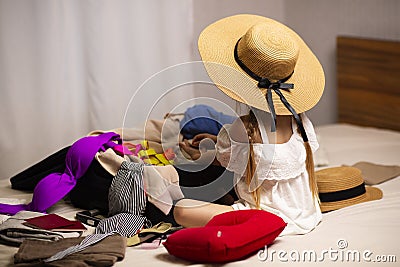 The girl is packing her suitcases for a new trip and a long weekend trip, vacation at the sea, wants a beach resort. Stock Photo
