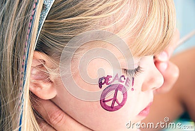 Girl with painted peace sign on face Stock Photo