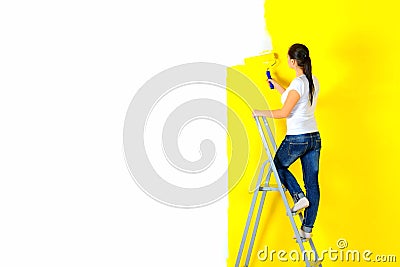 Girl painter paints a wall Stock Photo