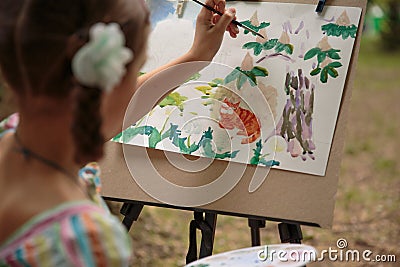 Girl paints on an easel in the drawing lesson Stock Photo