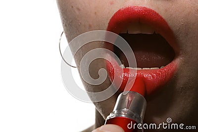 The girl paints her lips with red lipstick. Closeup. Stock Photo