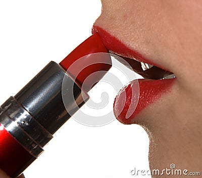 The girl paints her lips with red lipstick. Closeup. Stock Photo