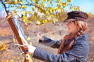 Girl with palette in hand sketches on paper Stock Photo