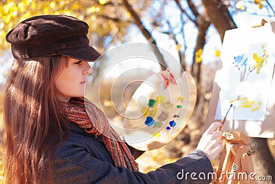 Girl with palette in hand sketches on paper Stock Photo