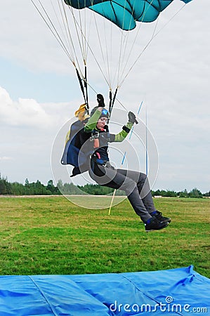 The girl-parachutist lands on airdrome Stock Photo