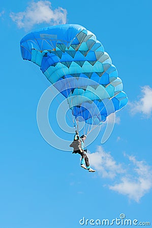 The girl-parachutist under a blue parachute Stock Photo