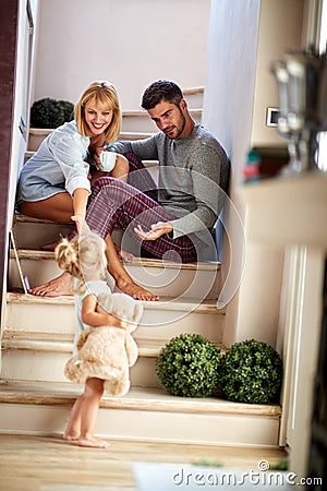 Girl with parents playing and holding teddy bear Stock Photo