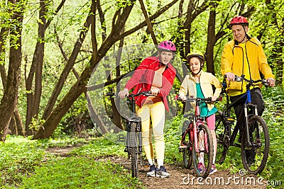 Girl with parents walking mounting biking trail Stock Photo