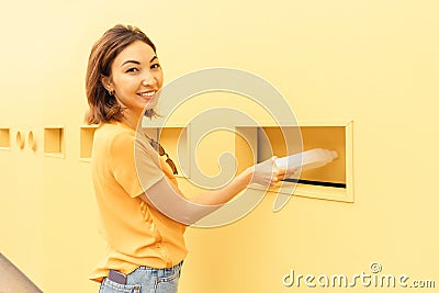 Girl passes a plastic bottle for recycling at the waste collection point. The concept of environmental awareness in the Stock Photo