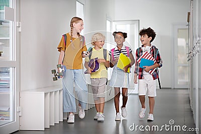 Girl with penny board walking with young pupils Stock Photo