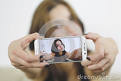 Girl photographing selfie herself with cell phone at home Stock Photo