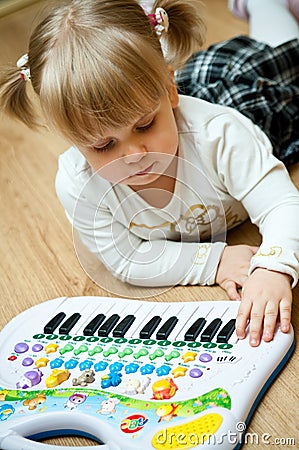 Girl with piano toy Stock Photo