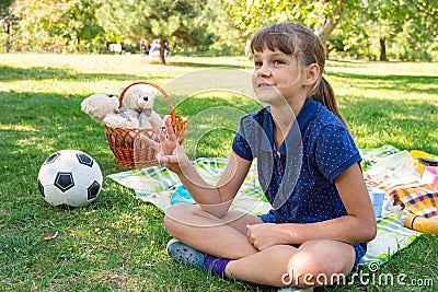Girl on a picnic counts goals scored on fingers Stock Photo