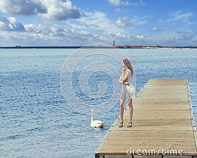 Girl on pier with swan Stock Photo