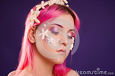 girl with pink hair and professional make-up sea princess with starfish and shells on her face and head Stock Photo