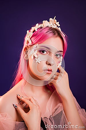 girl with pink hair and professional make-up sea princess with starfish and shells on her face and head Stock Photo