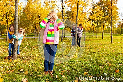 Girl play hide and seek with friends Stock Photo