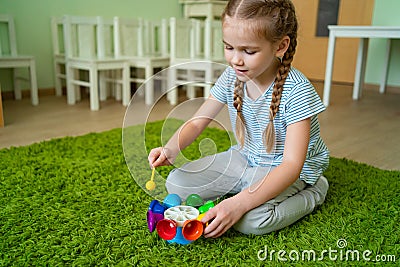 Girl play with whirligig colourful musical bells Stock Photo