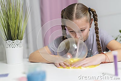 Girl play with yellow slime inflates bubble fun at home Stock Photo