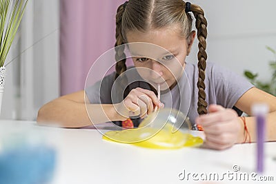 Girl play with yellow slime inflates bubble fun at home Stock Photo