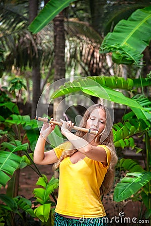 Girl playing the bamboo flute Stock Photo