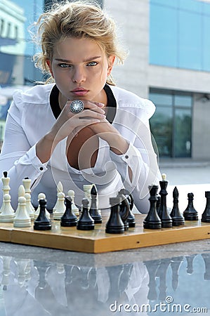 Girl playing chess outdoors. Stock Photo