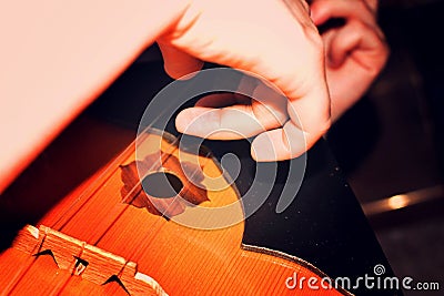 The girl is playing dombra and beating the chords on the guitar, close-up. Stock Photo