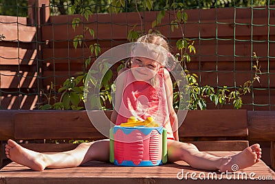 Girl playing with a drum in wooden arbor Stock Photo