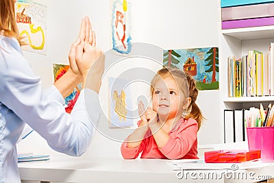 Girl playing finger games with teacher Stock Photo