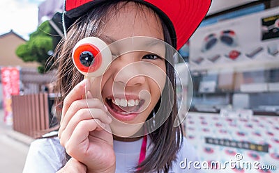 Girl playing with Ghost Eye Moji candy Stock Photo